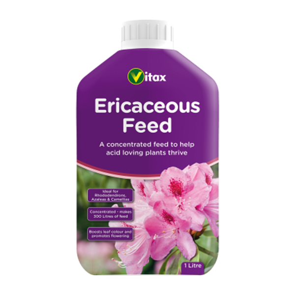 A purple Vitax bottle labeled Ericaceous Feed - 1 Litre, designed for acid-loving plants, features pink flowers on its packaging. It contains 1 litre of concentrated feed that enhances blooming and is perfect for caring for rhododendrons, azaleas, and camellias.